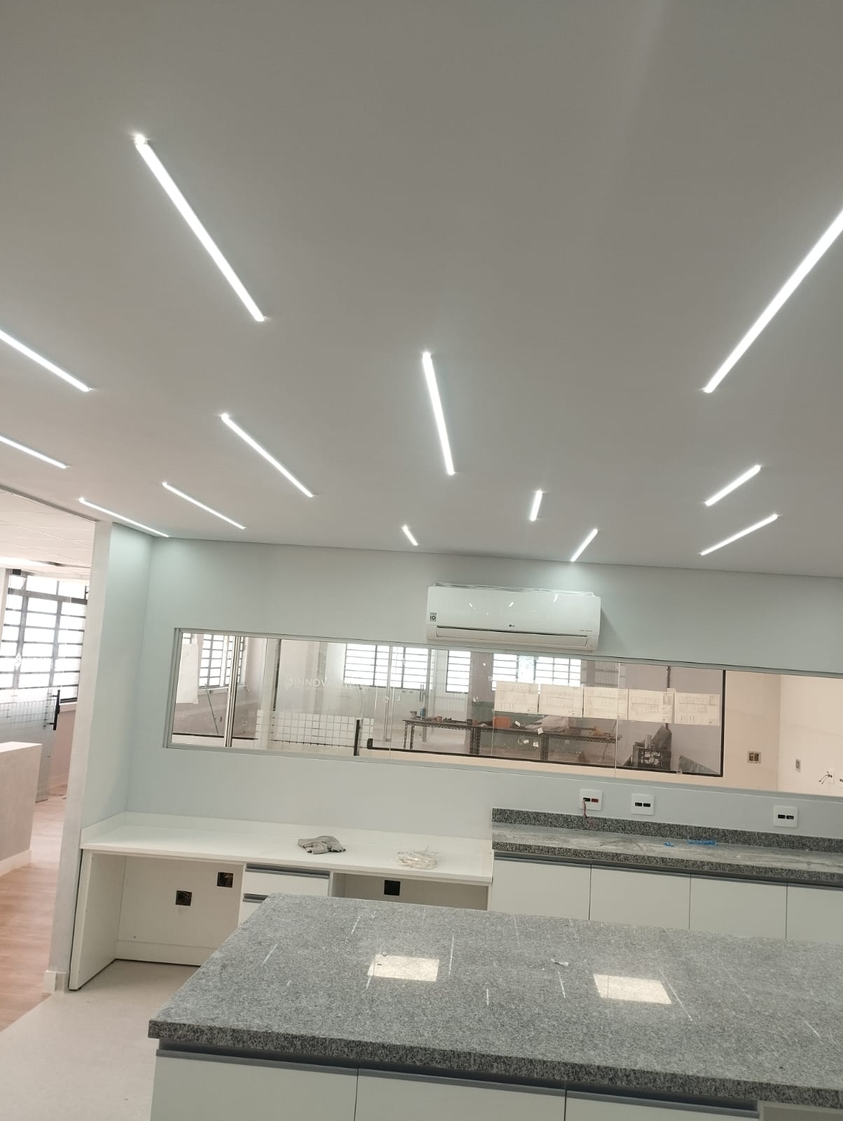 Salão comercial com luminárias lineares de LED no forro e bancadas em granito, serviço executado pela WSC