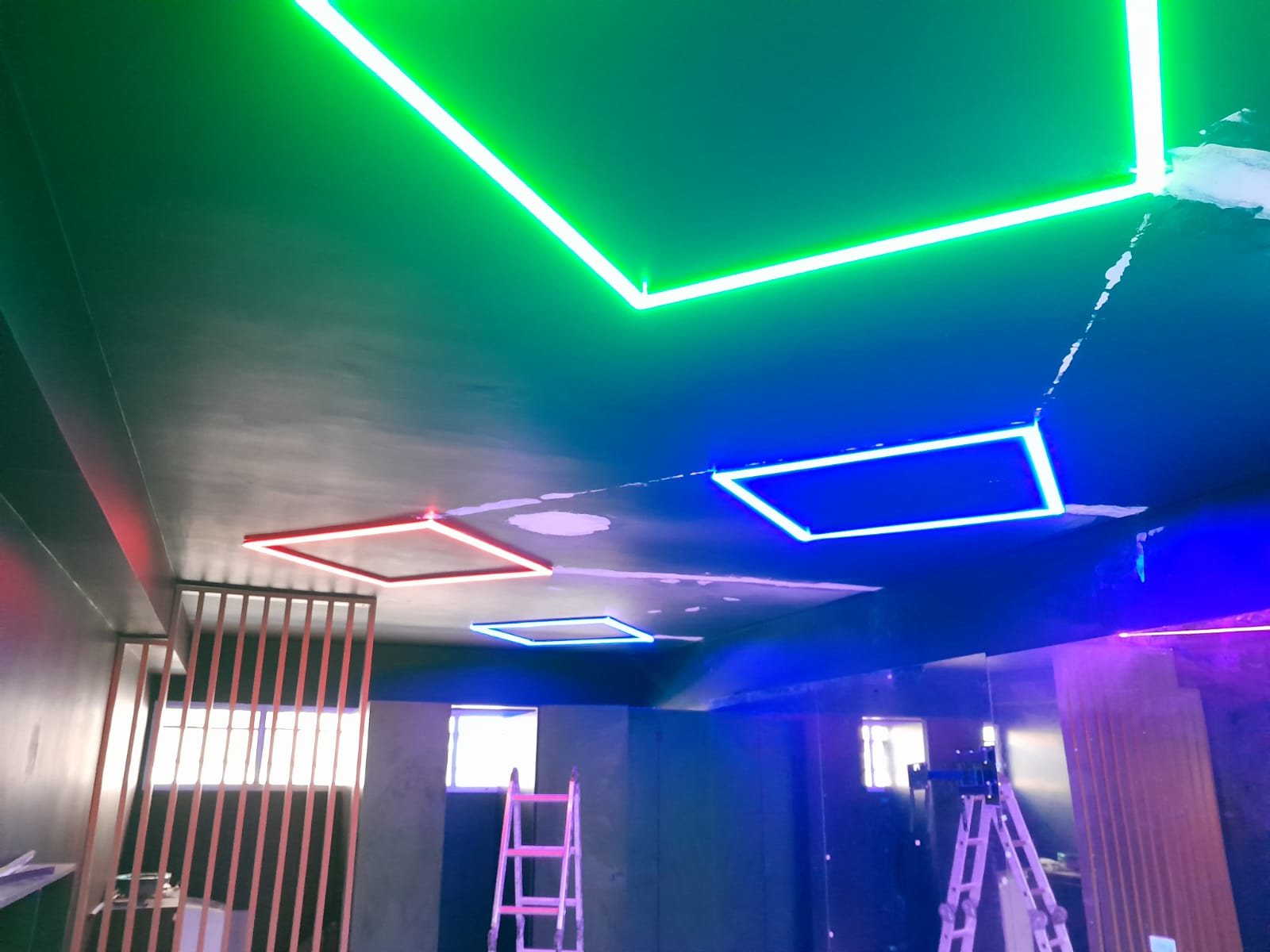 Iluminação de LED em verde e azul instalada em teto de loja