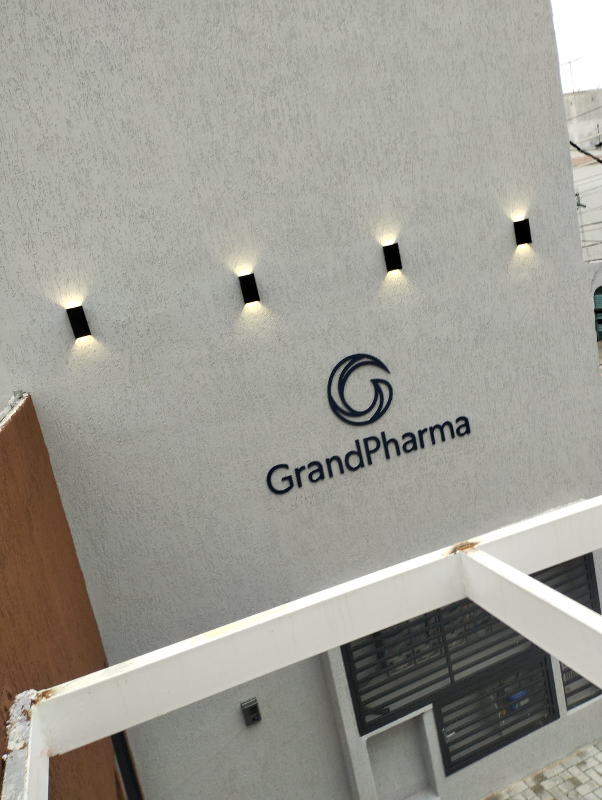 Fachada comercial com letreiro e arandelas de LED acesas